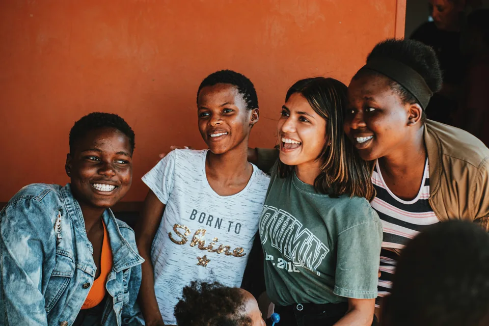 A group of young people smiling together.