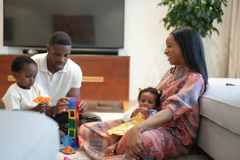 Parents and children playing together at home.