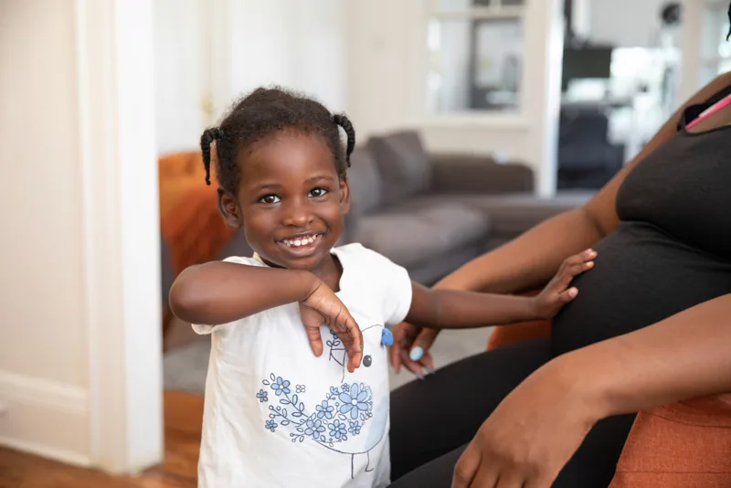 A little girl smiling indoors.