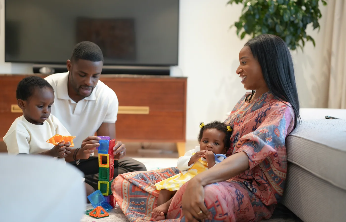 Parents and their children playing happily together at home.