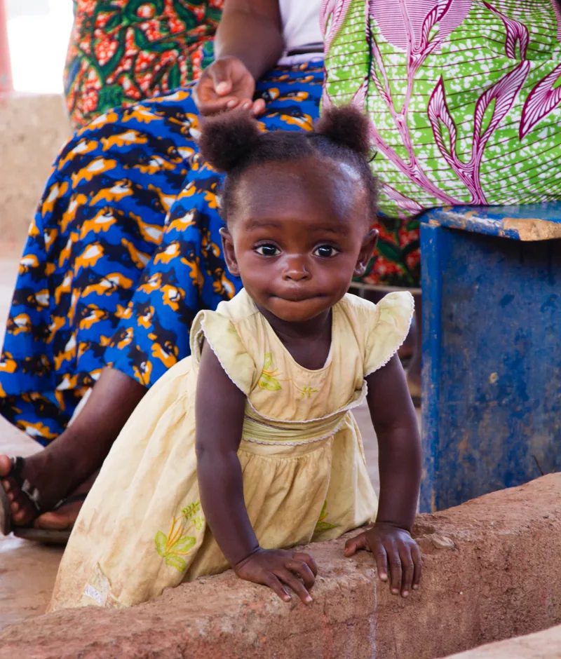 A mother and her young daughter smiling together.