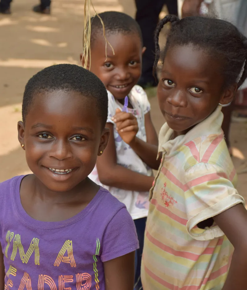 Children smiling together outdoors.