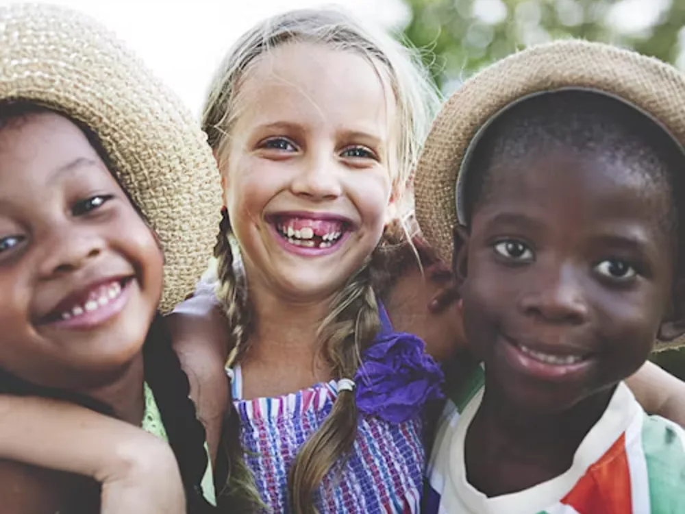 Children smiling together outdoors.